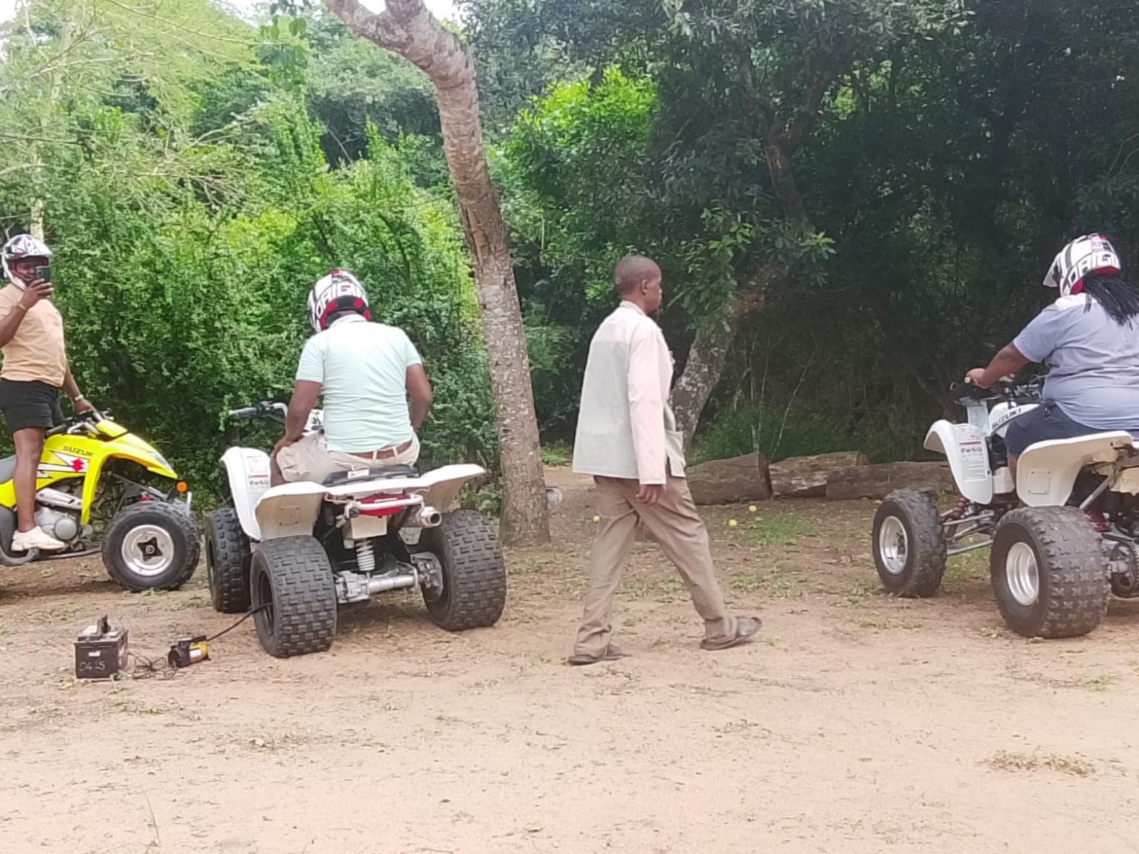 Quad bike adventure guide assisting guests near Hluhluwe